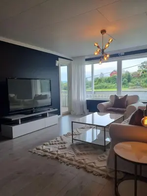 a living room with a flat screen tv and a couch at Nyoppusset leilighet nær Aker og sentrum in Stord