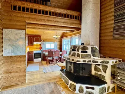 a living room with a fireplace in a log cabin at Beitostølen Cabin - Sauna, large terrace and BBQ in Beitostøl