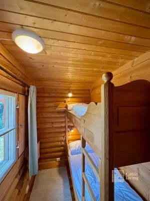 a bedroom with two bunk beds in a log cabin at Beitostølen Cabin - Sauna, large terrace and BBQ in Beitostøl