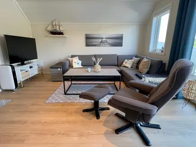 a living room with a couch and chairs and a table at 8 person holiday home in Urangsvåg in Ervik