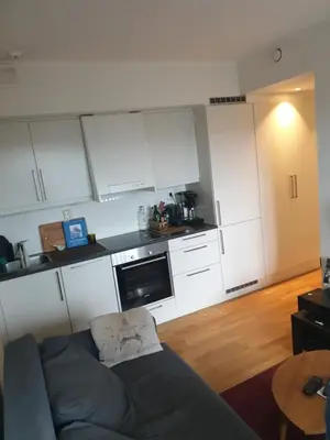 a living room with a couch and a kitchen at Modern apartment in Trondheim
