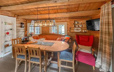 a dining room with a wooden table and chairs at 4 Bedroom Cozy Home In Nordberg in Nordberg