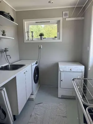 a small kitchen with a sink and a washing machine at Korssundvegen 230 in Korssund