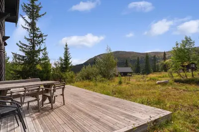 a wooden deck with a bench and a table at Trysilfjell 811 by Vacation Trysil in Trysil