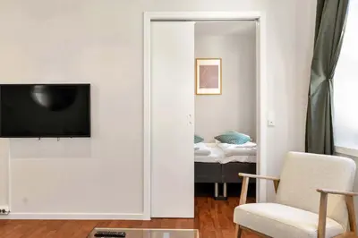 a living room with a tv and a bedroom at Harbour - 1BR Apartment in Bergen