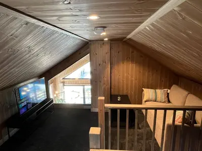 a living room with a couch and a television in a cabin at Skogsbu - Stylish, Close to Ski centers and hiking trails in Nesbyen