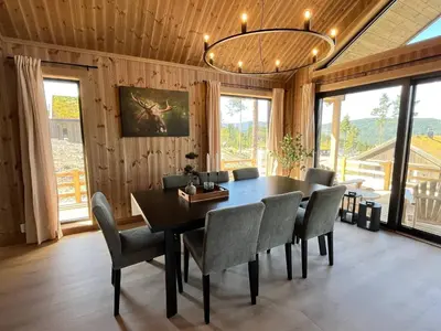a dining room with a table and chairs and a chandelier at Skogsbu - Stylish, Close to Ski centers and hiking trails in Nesbyen