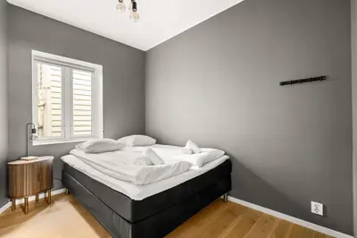 a bedroom with a bed with white sheets and a window at Light & Modern, City Apartment in Bergen