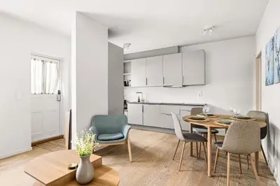 a kitchen and dining room with a table and chairs at Light & Modern, City Apartment in Bergen