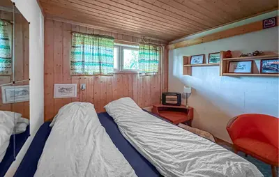 a small bedroom with a bed and a chair at Lovely Home In Hamar With Wifi in Hamar