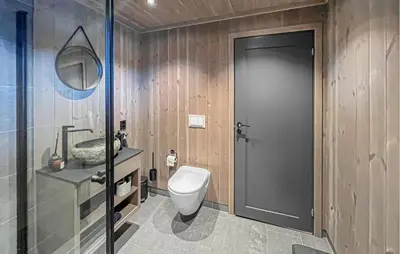 a bathroom with a toilet and a glass door at Cozy Home In Svingvoll With House A Mountain View in Svingvoll