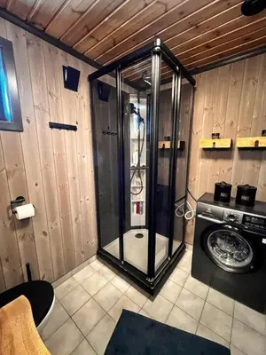 a shower in a room with a washing machine at Newly Renovated Cabin By Sjusjoen Ski Slopes in Sjusjøen