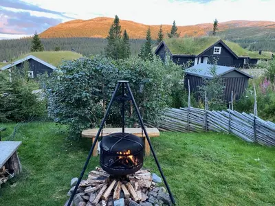 a grill sitting on top of a pile of logs at Cosy ski-in ski-out mountain cabin with sauna in Trysil