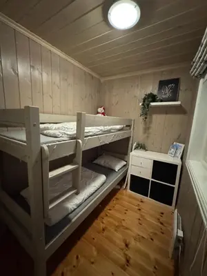 a room with two bunk beds and a table at Cosy ski-in ski-out mountain cabin with sauna in Trysil
