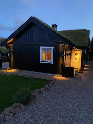 a black house with a window on the side of it at Cosy ski-in ski-out mountain cabin with sauna in Trysil
