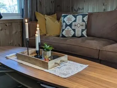 a living room with a couch and a table with a candle at Luxury Mountain Cabin with Hot Tub and Views in Budal in Storen
