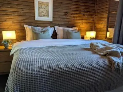 a bedroom with a large white bed with two lamps at Luxury Mountain Cabin with Hot Tub and Views in Budal in Storen