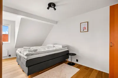 a bedroom with a bed in the corner of a room at Spacious Gem In Old Town I NEW 2025 I 3 Bed 2 Bath in Bergen