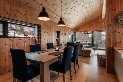 a dining room with a wooden table and chairs at Moderne leilighet i Vestlia-Ski in ski out in Geilo