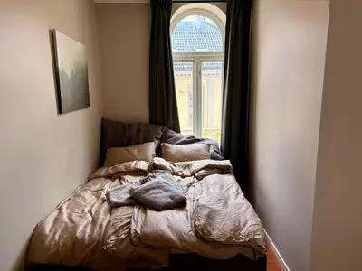 a bed in a room with a window at Apartment in apartment building, close to the train station in Bergen