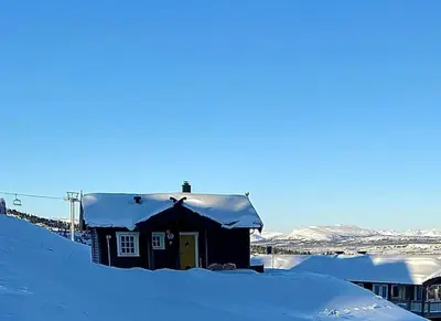 a house with a snow covered roof in the snow at Traditional Cabin With Annex In The Mountains in Gol