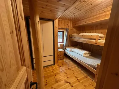 a room with two bunk beds in a wooden cabin at Bjorliheimen Fjellhotell-Hytte 11 & 12 in Bjorli