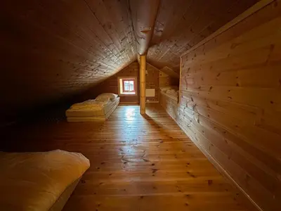 an attic room with two beds and a window at Bjorliheimen Fjellhotell-Hytte 11 & 12 in Bjorli