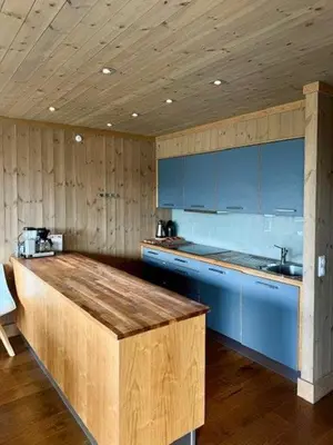 a kitchen with blue cabinets and a wooden counter top at Lodge With Views Of Gaustatoppen Mountain in Rjukan