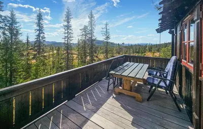 a wooden deck with a bench and a table and chairs at 4 Bedroom Stunning Home In Tuddal in Tuddal
