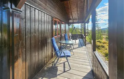 a wooden porch with a table and chairs on it at 4 Bedroom Stunning Home In Tuddal in Tuddal