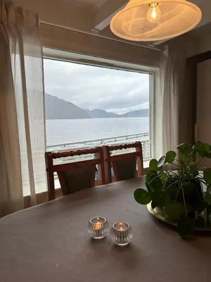 a dining room table with a view of the ocean at Sauda 4 bedrooms near skiing with view of fjord in Sauda