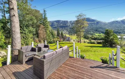 a wooden deck with two couches and a tree at Stunning Home In Vikebygd With House A Mountain View in Vikebygd
