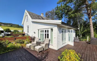 a white house with chairs and a table on a patio at Stunning Home In Vikebygd With House A Mountain View in Vikebygd