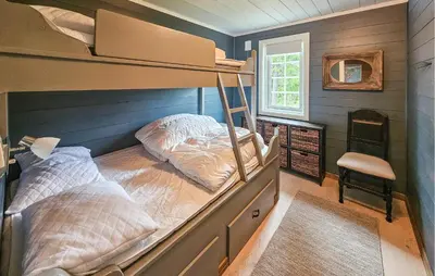 a bedroom with a bunk bed and a chair at Amazing Home In Veggli With Wifi in Veggli