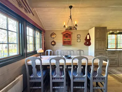 a kitchen with a table with chairs around it at Briskebu, cosy cabin by ski slopes in Geilo