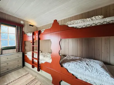 a room with two bunk beds in a house at Briskebu, cosy cabin by ski slopes in Geilo