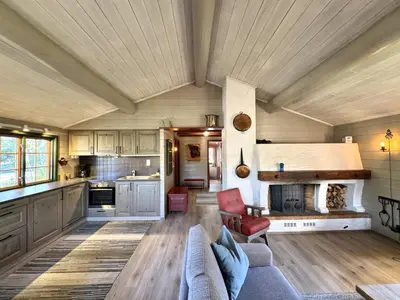 a large kitchen with a couch and a table at Briskebu, cosy cabin by ski slopes in Geilo