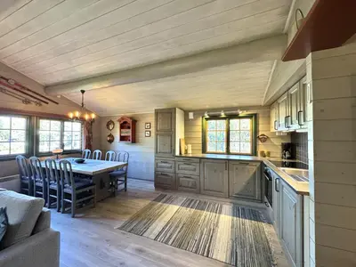 a kitchen and dining room with a table and chairs at Briskebu, cosy cabin by ski slopes in Geilo