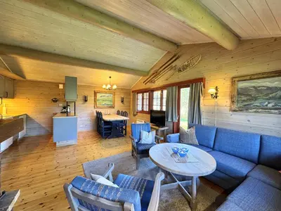 a living room with a blue couch and a table at Tvilsombu, cosy cabin close to ski slopes in Geilo