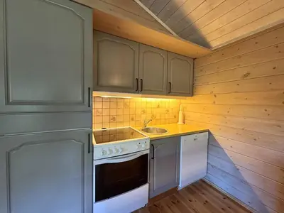 a kitchen with a stove and a sink at Tvilsombu, cosy cabin close to ski slopes in Geilo