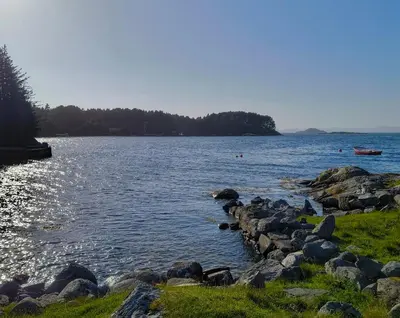 a large body of water with people swimming in it at Retreat Øklandsnes in Lii