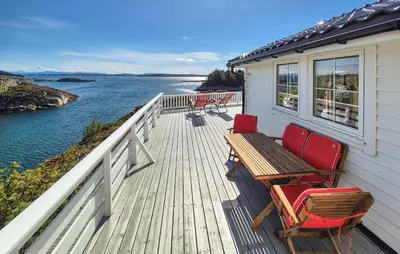 a deck with chairs and a wooden table and bench at 4 Bedroom Gorgeous Home In Steinsland in Steinsland