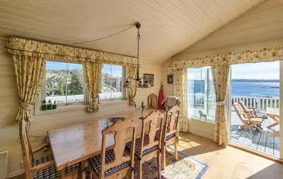 a dining room with a table and views of the ocean at 4 Bedroom Gorgeous Home In Steinsland in Steinsland