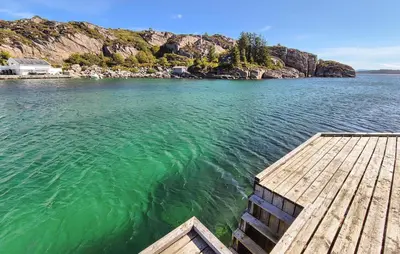 a dock on a body of water with a mountain at 4 Bedroom Gorgeous Home In Steinsland in Steinsland