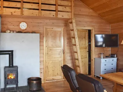 a living room with a wood stove in a cabin at 6 person holiday home in Bud-By Traum in Bud