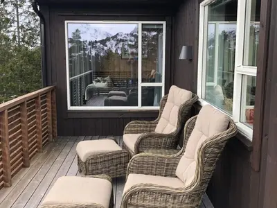 two wicker chairs sitting on a porch with a window at 12 person holiday home in Skare-By Traum in Skare