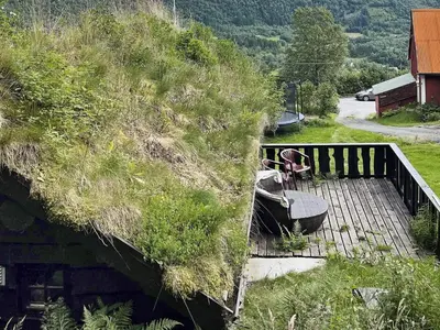 a boat on a wooden deck with a grassy hill at 4 person holiday home in Bryggja-By Traum in Bryggja