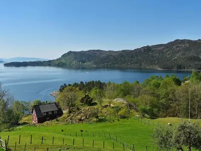 a barn on a hill next to a lake at 6 person holiday home in Onarheim in Onarheim