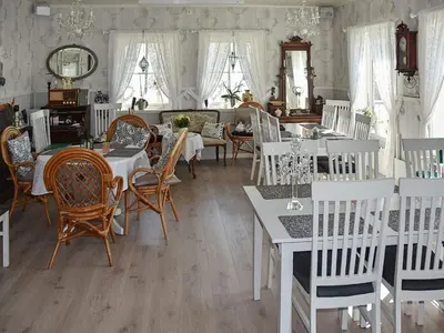 a dining room with white tables and chairs at 6 person holiday home in Onarheim in Onarheim