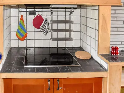 a kitchen with a stove top oven in a kitchen at 8 person holiday home in FREI in Frei